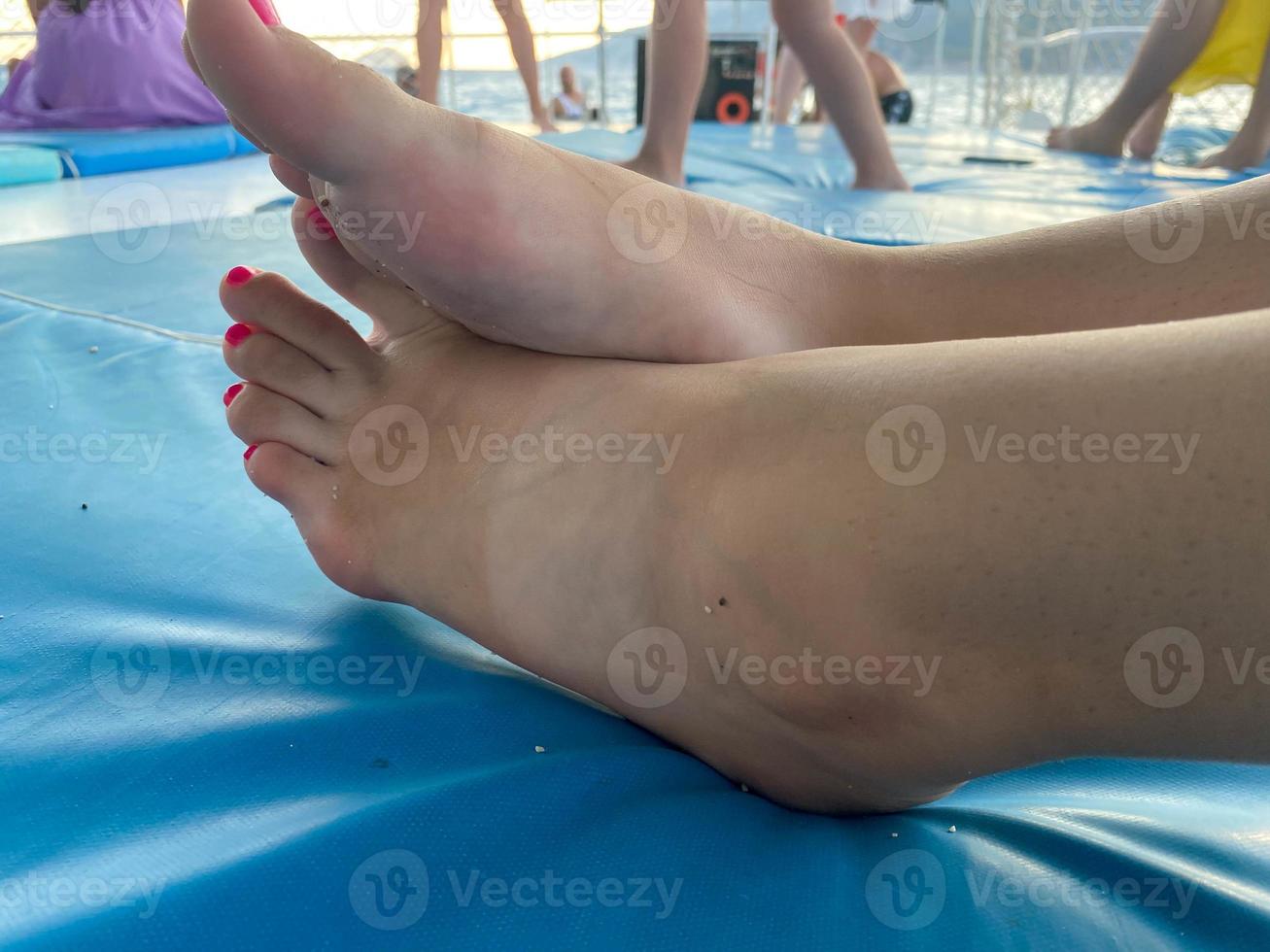 piernas femeninas con los pies descalzos sobre una alfombra de yoga verde foto