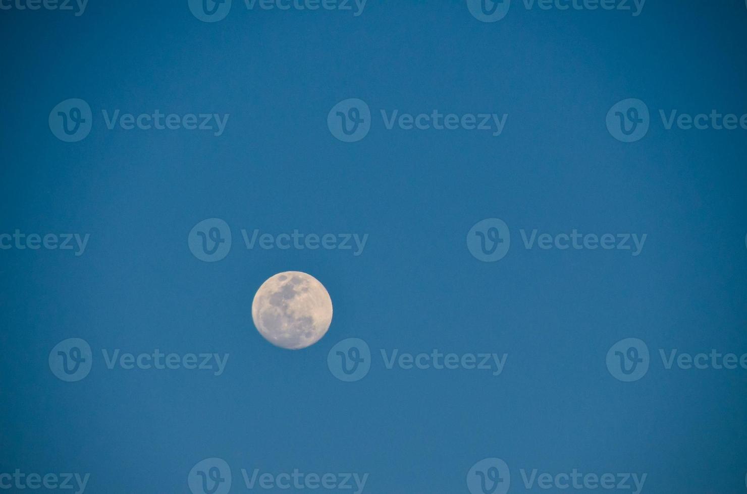 Moon in blue sky photo