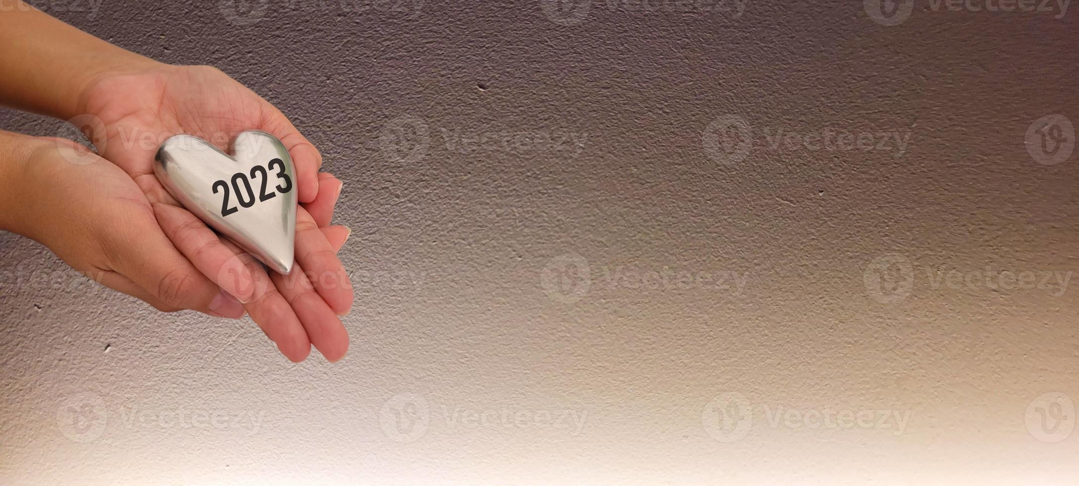 mano sosteniendo corazón 2023 vista superior y fondo blanco con sombra foto
