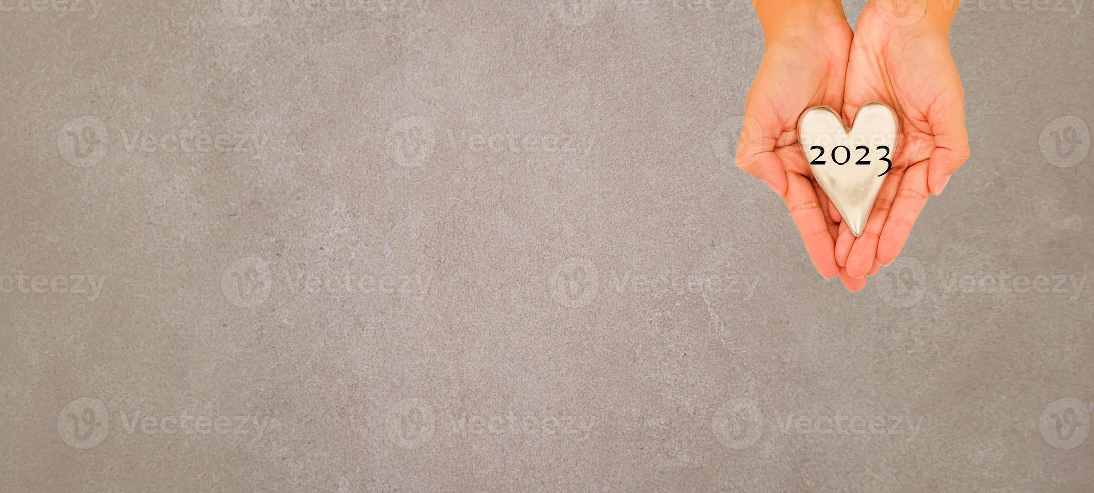 hand holding heart 2023 top view and white background with shadow photo
