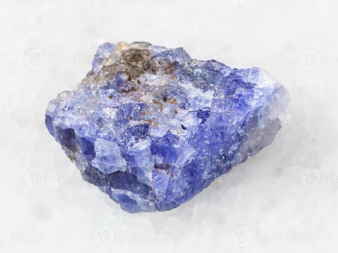 cristal en bruto de piedra preciosa de tanzanita en blanco foto