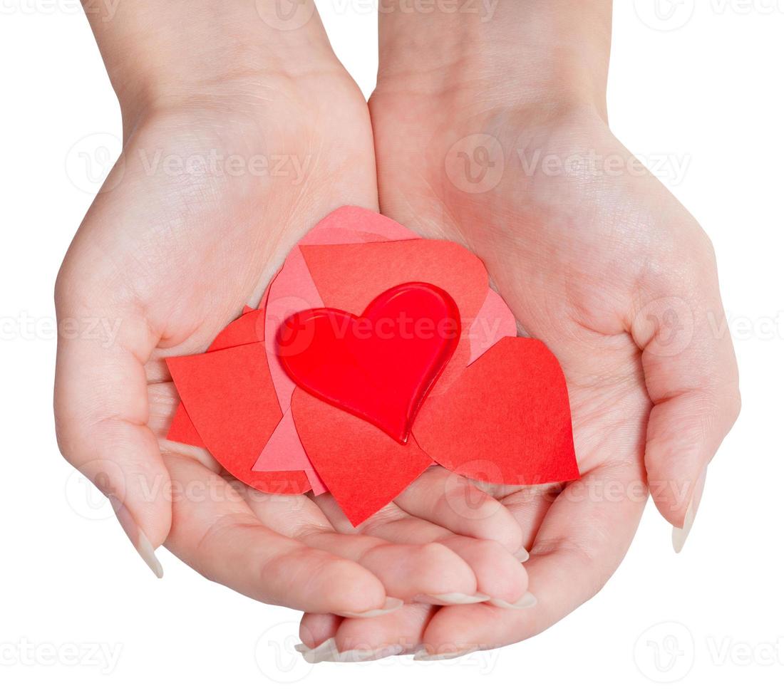 heart above pile of paper hearts on female palms photo