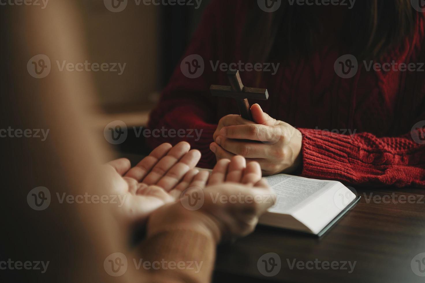 dos personas leyendo y estudiando la biblia en casa y orando juntas. estudiando la palabra de dios foto