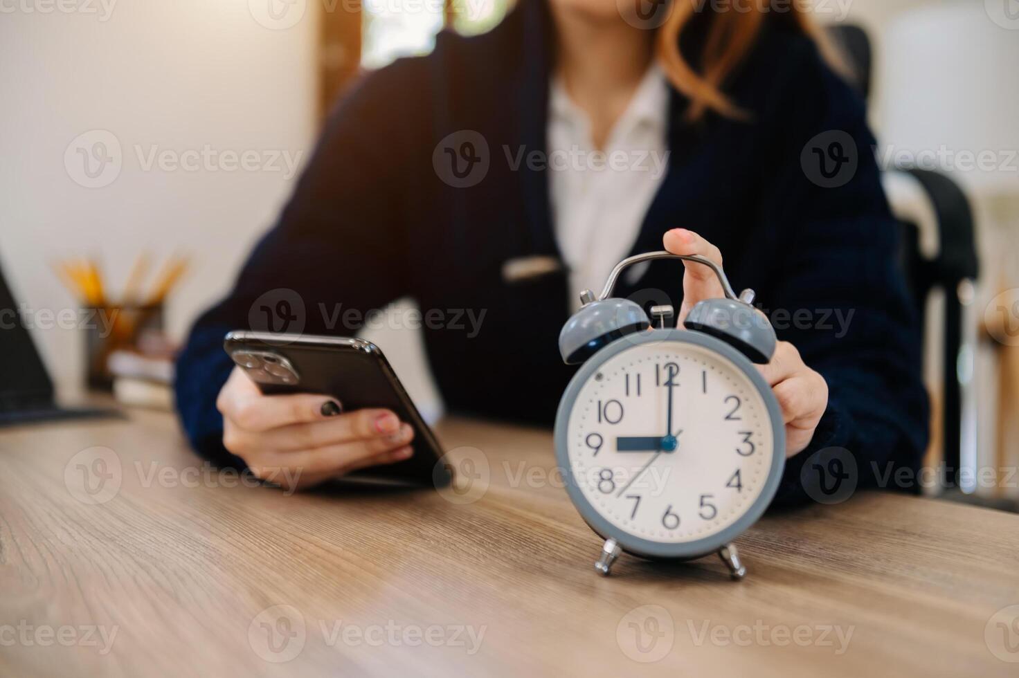 Alarm clock on the desk. Business working in modern office building or home at night using laptop. photo