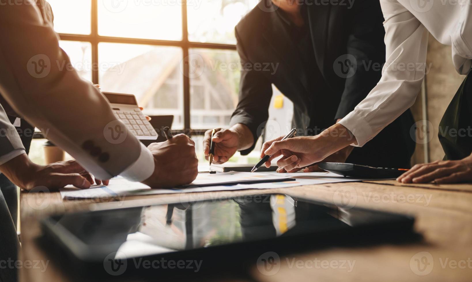 Business documents on office table with smart phone and calculator digital tablet and graph business with social network diagram and two colleagues discussing data working in the office photo