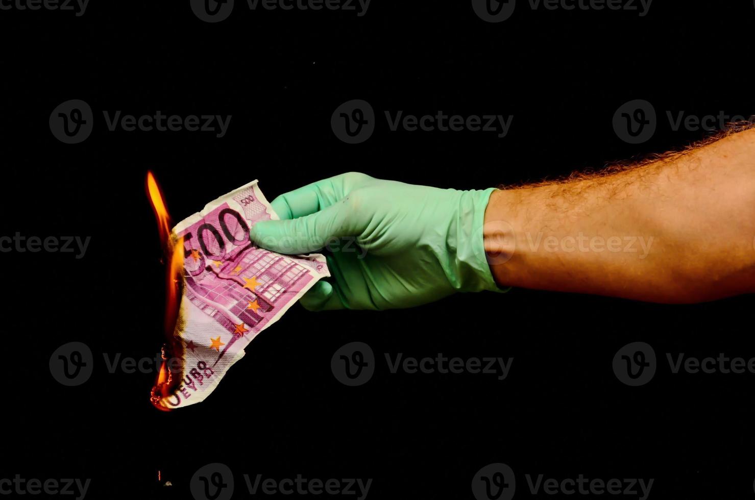 Hand holding Euro cash burning photo