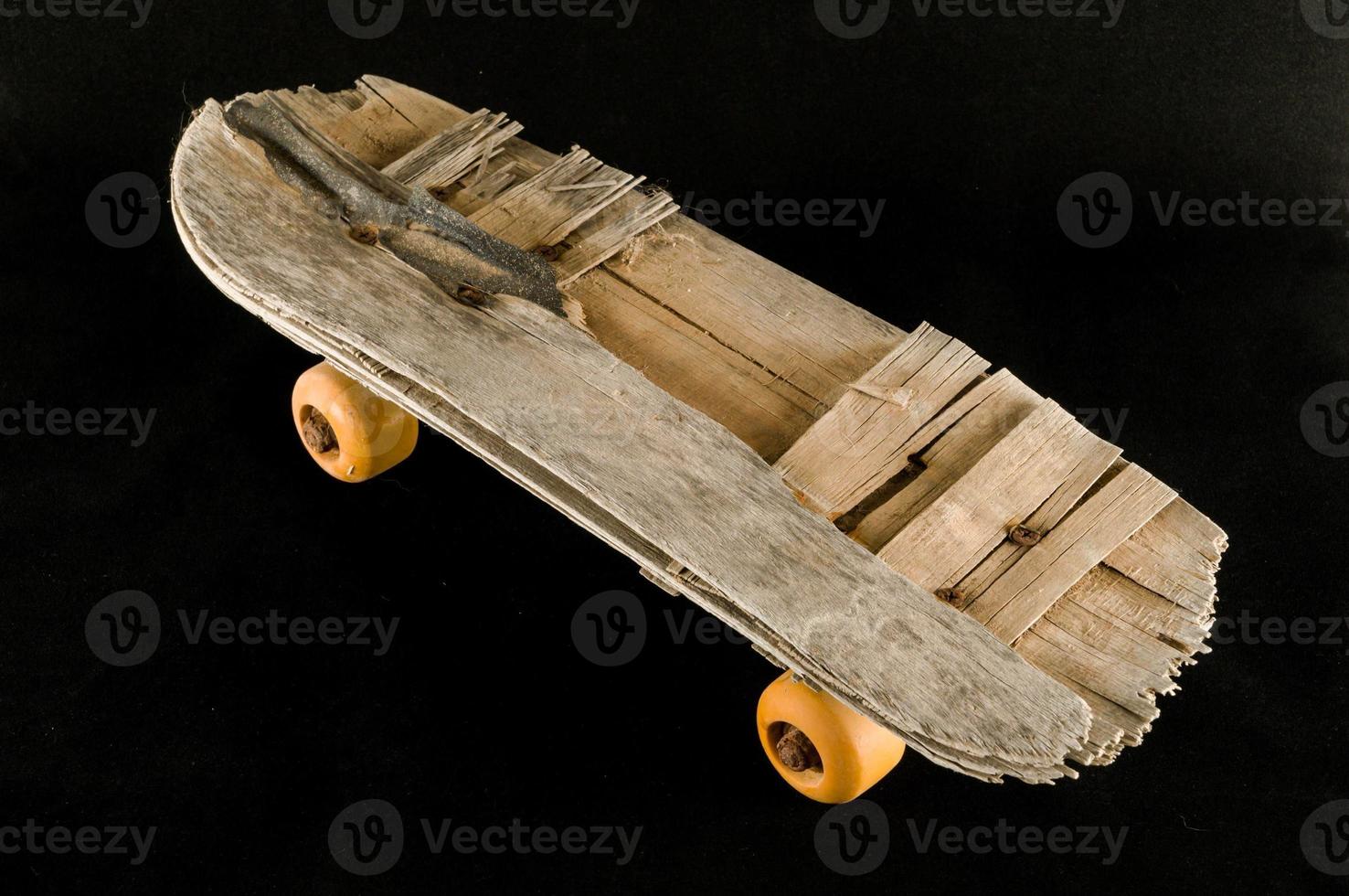 Old skateboard on black photo