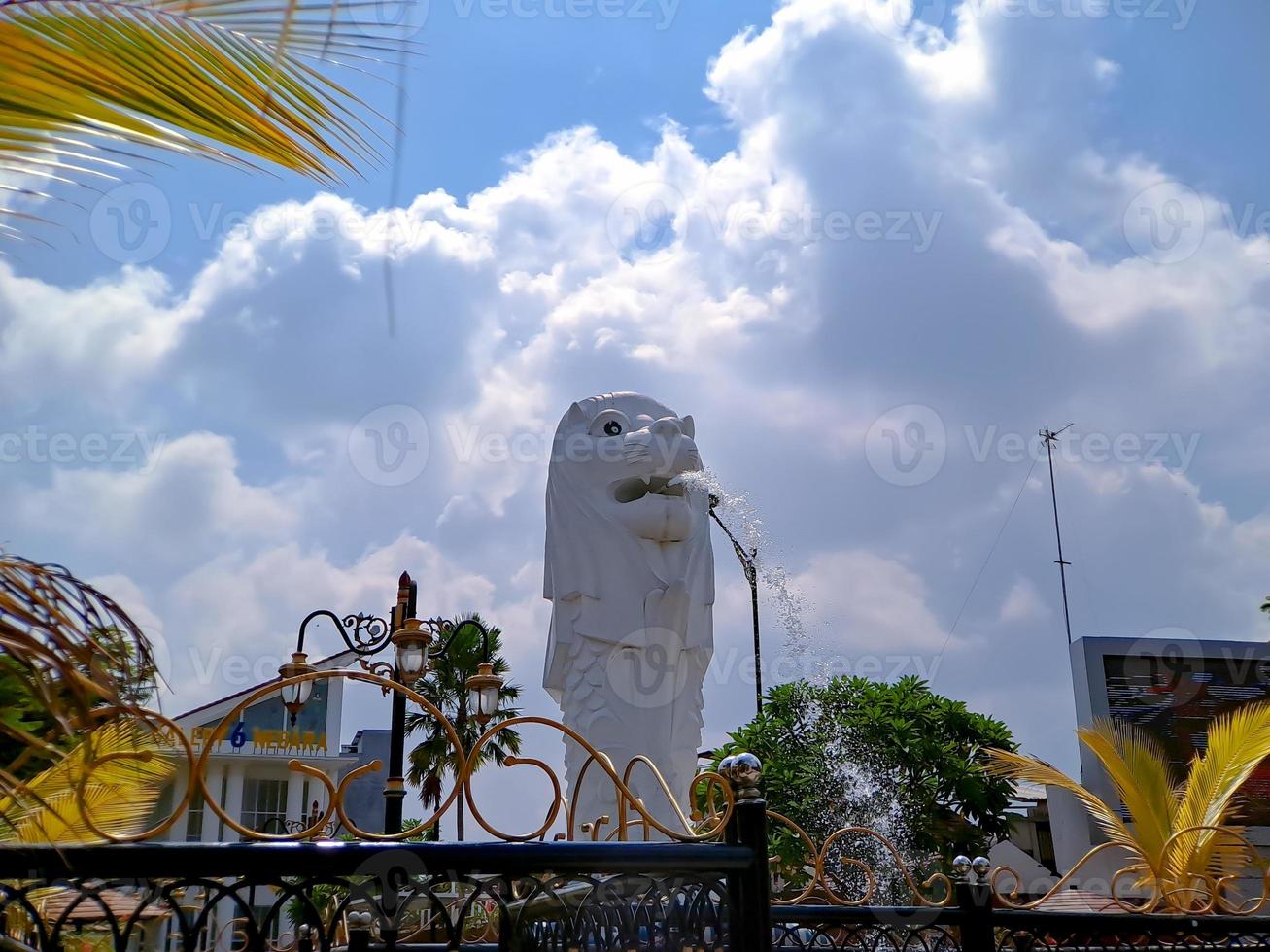 Replica of Singapore white lion statue, in the city park of Madiun Indonesia with clear blue sky. photo