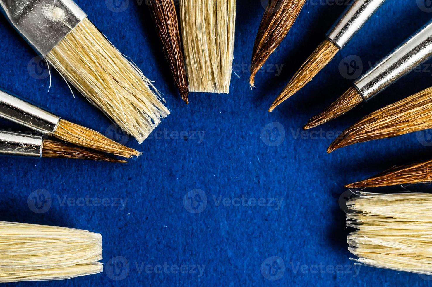 Assorted paint brushes on blue background photo