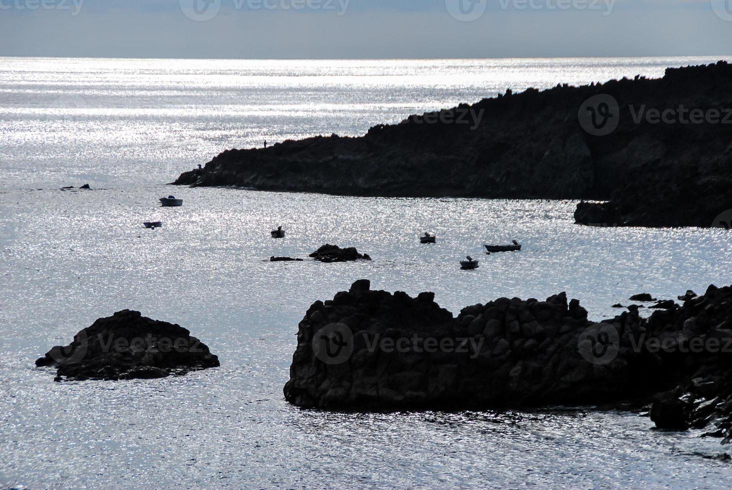 Ocean and silhouetted land photo