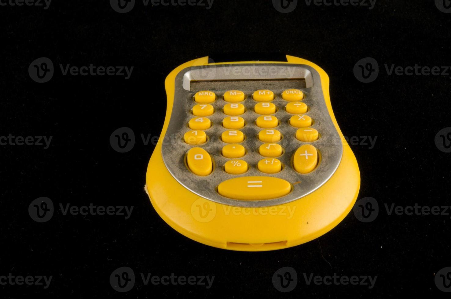 Yellow calculator on black photo