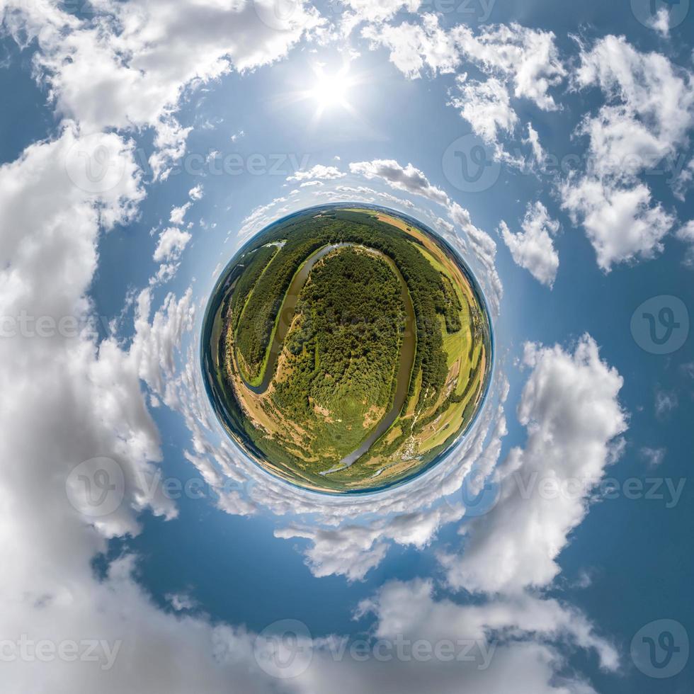 green tiny planet in blue overcast sky with beautiful clouds with transformation of spherical panorama 360 degrees. Spherical abstract aerial view. Curvature of space. photo