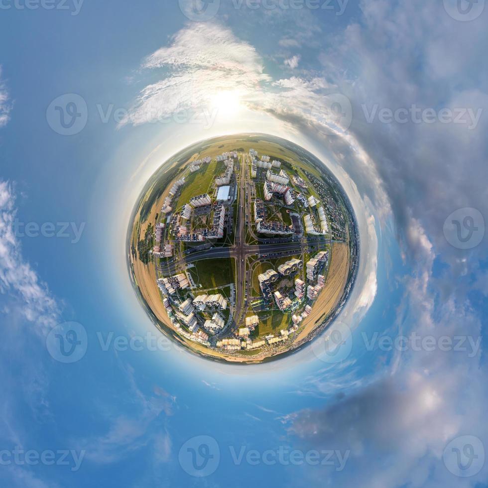 tiny planet in sky with clouds overlooking old town, urban development, historic buildings and crossroads. Transformation of spherical 360 panorama in abstract aerial view. photo