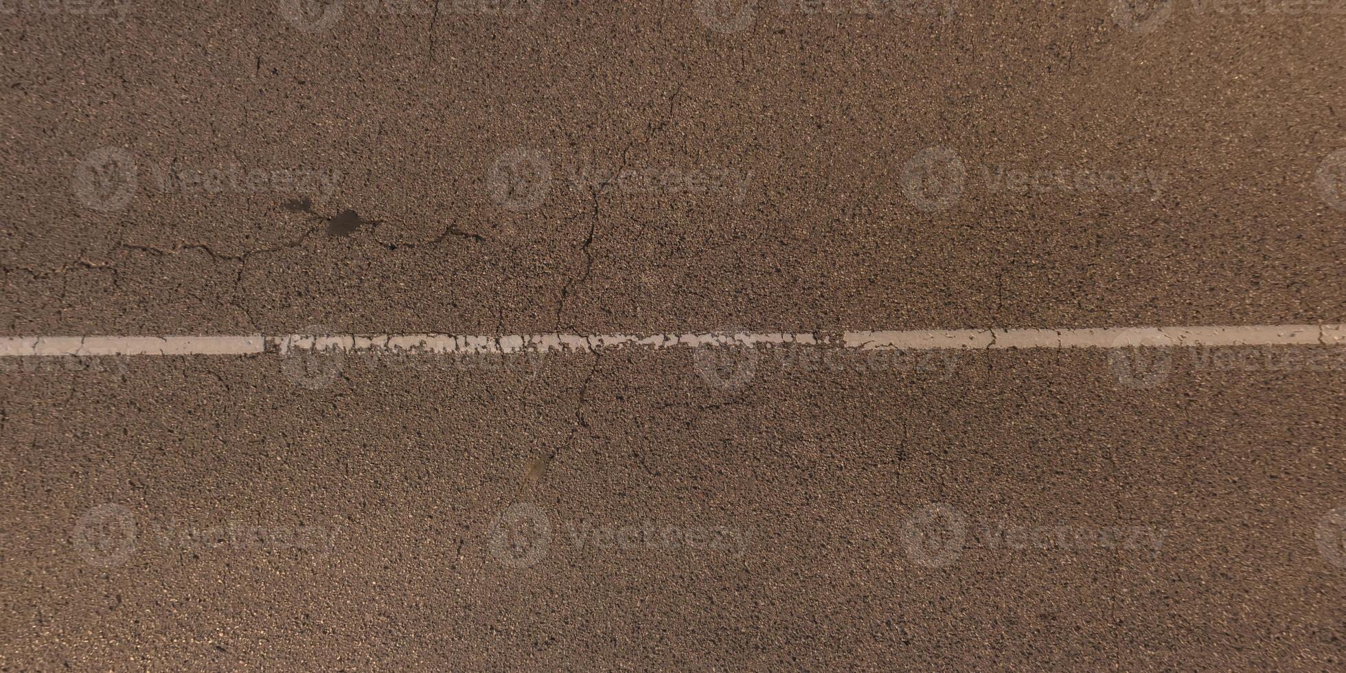 panorama view from above on surface texture of old asphalt road with cracks photo