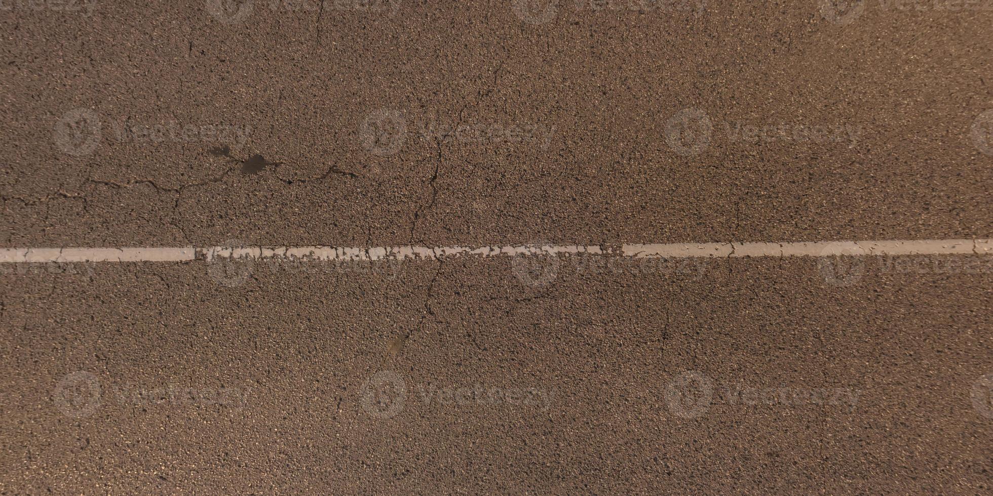 panorama view from above on surface texture of old asphalt road with cracks photo