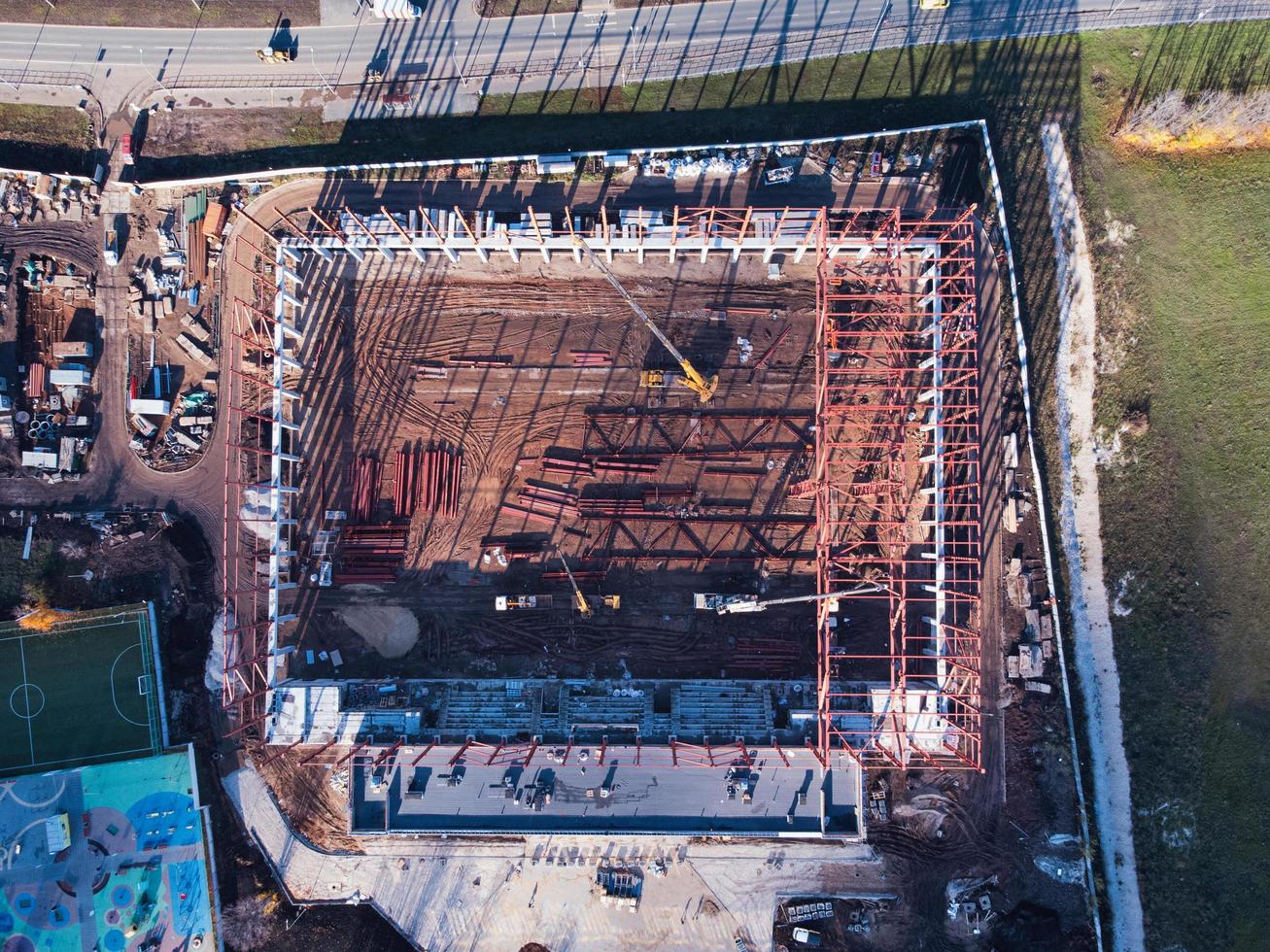 vista aérea de arriba hacia abajo del sitio de construcción con grúas de camión y elementos del marco de metal. foto