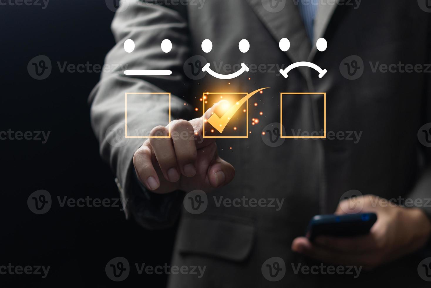 Customer service evaluation best excellent business rating experience concept. smiling man using a smartphone and pressing face emoticon smile in satisfaction on virtual touch screen. photo