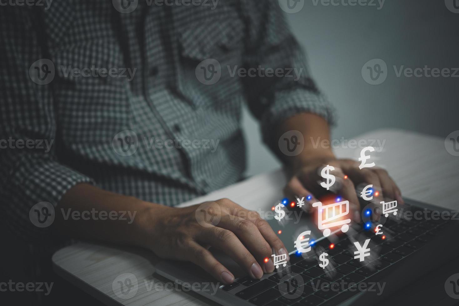 ícono de carrito de compras virtual y signo de moneda, comprar en Internet, comercio electrónico, mano de hombre de negocios escribiendo en el teclado con concepto de compras en línea. foto