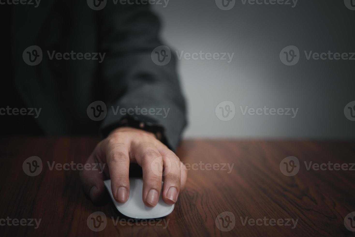 Hand using computer mouse, clicking pointer laptop on desk. photo