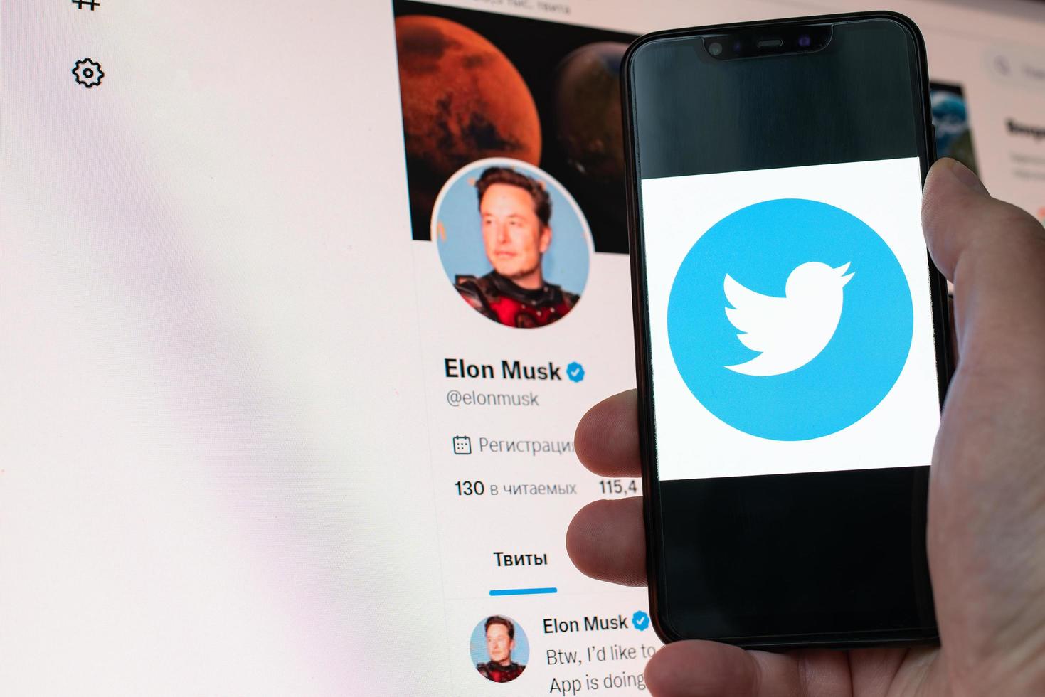 Kyiv, Ukraine, November 14, 2022 - Elon Musk official Twitter profile on monitor and social media logo seen displayed on a smartphone close up in hand. Elon Musk reaches agreement to acquire Twitter photo