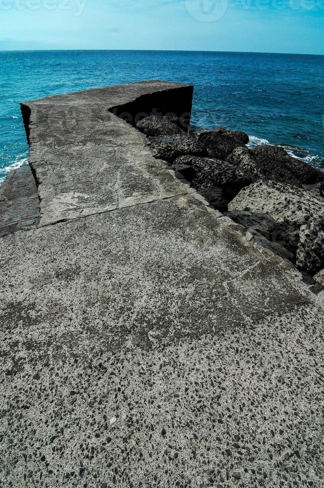 Concrete pier by the ocean photo