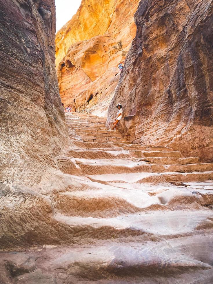 Caucasian tourist girl stand on staircase to A'dir monastery on mountain in Petra lost city historical landmark photo
