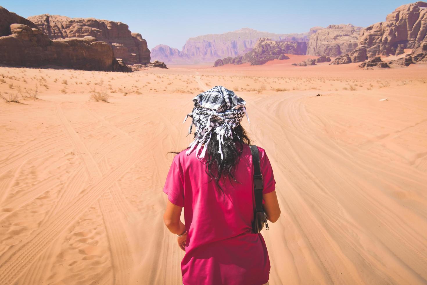 Back view female tourist stand watch point finger to wadi rum desert landscape in jordan desert-famous nature reserve in middle east. Explore Jordan banner photo