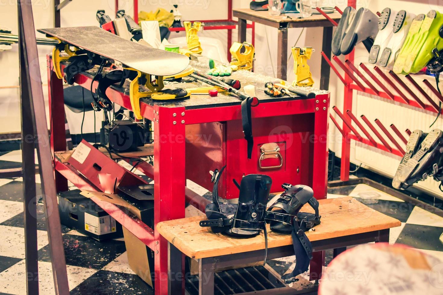 Set for the preparation of skis and snowboards - iron, brushes, scraper, ski lubricant - paraffin, skis on a black and red background. Empty space for the inscription. photo