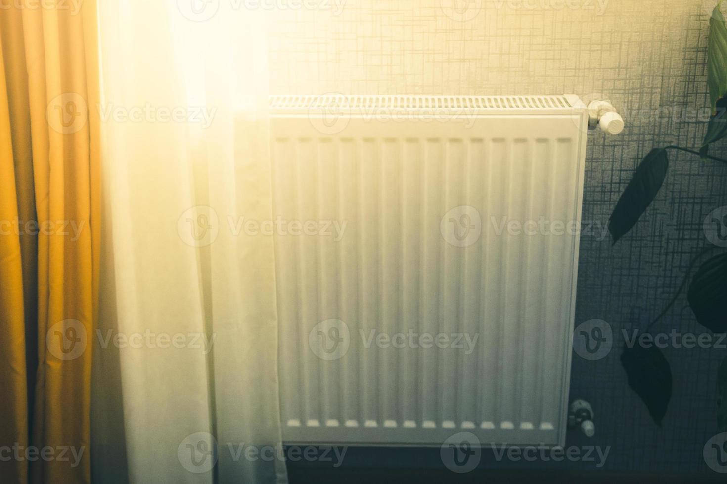 radiador blanco con válvula de control de temperatura calefacción central en edificios modernos por ventana. foto