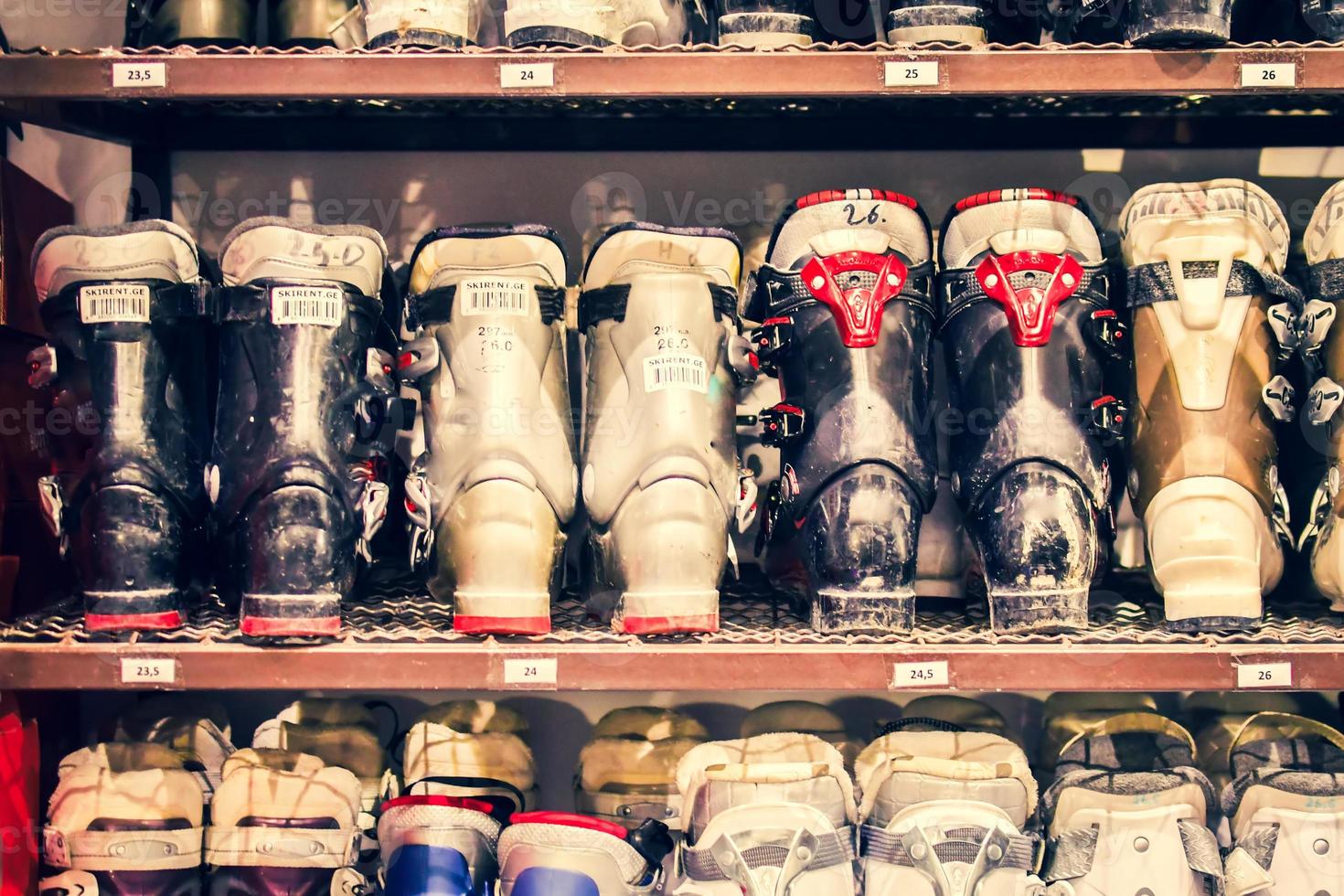 Various ski boots in ski rental shop for rental on ski resort for clients or customers photo