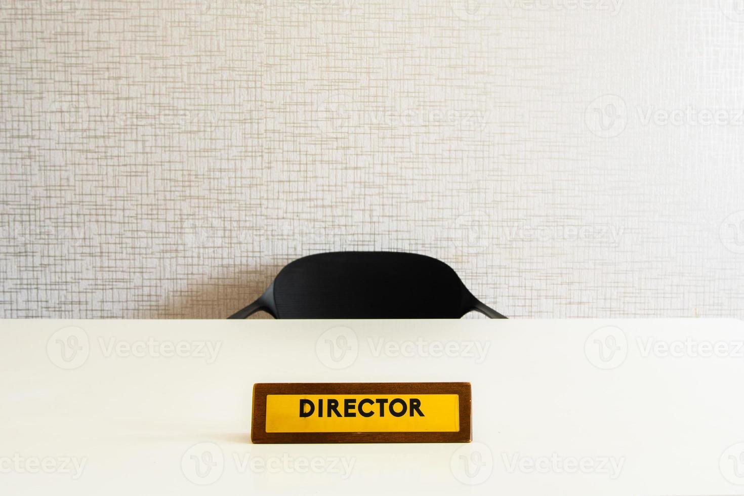 placa de oficina de director de madera sobre mesa blanca brillante con silla vacía en la habitación foto