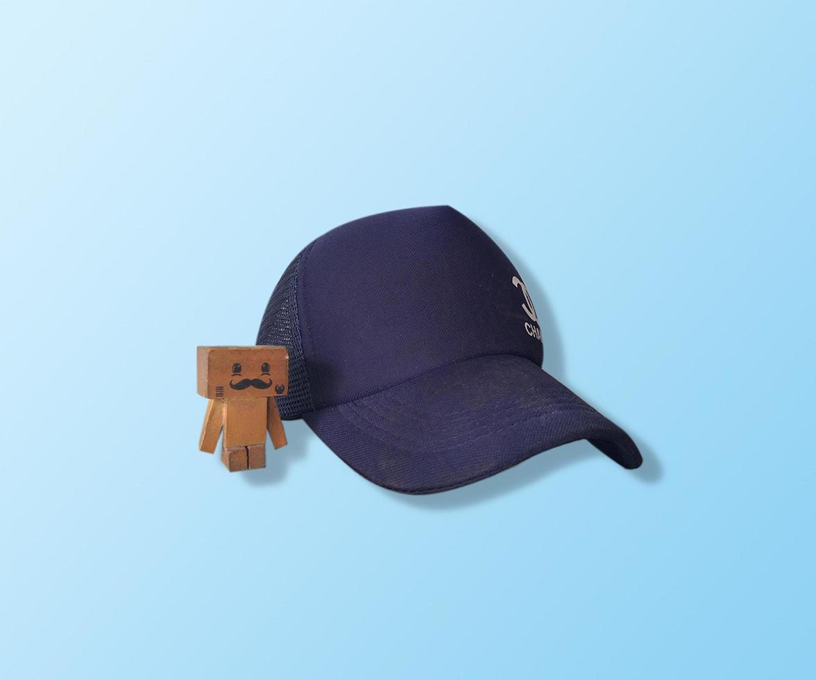 hat and wooden doll isolated on white blue gradient background photo
