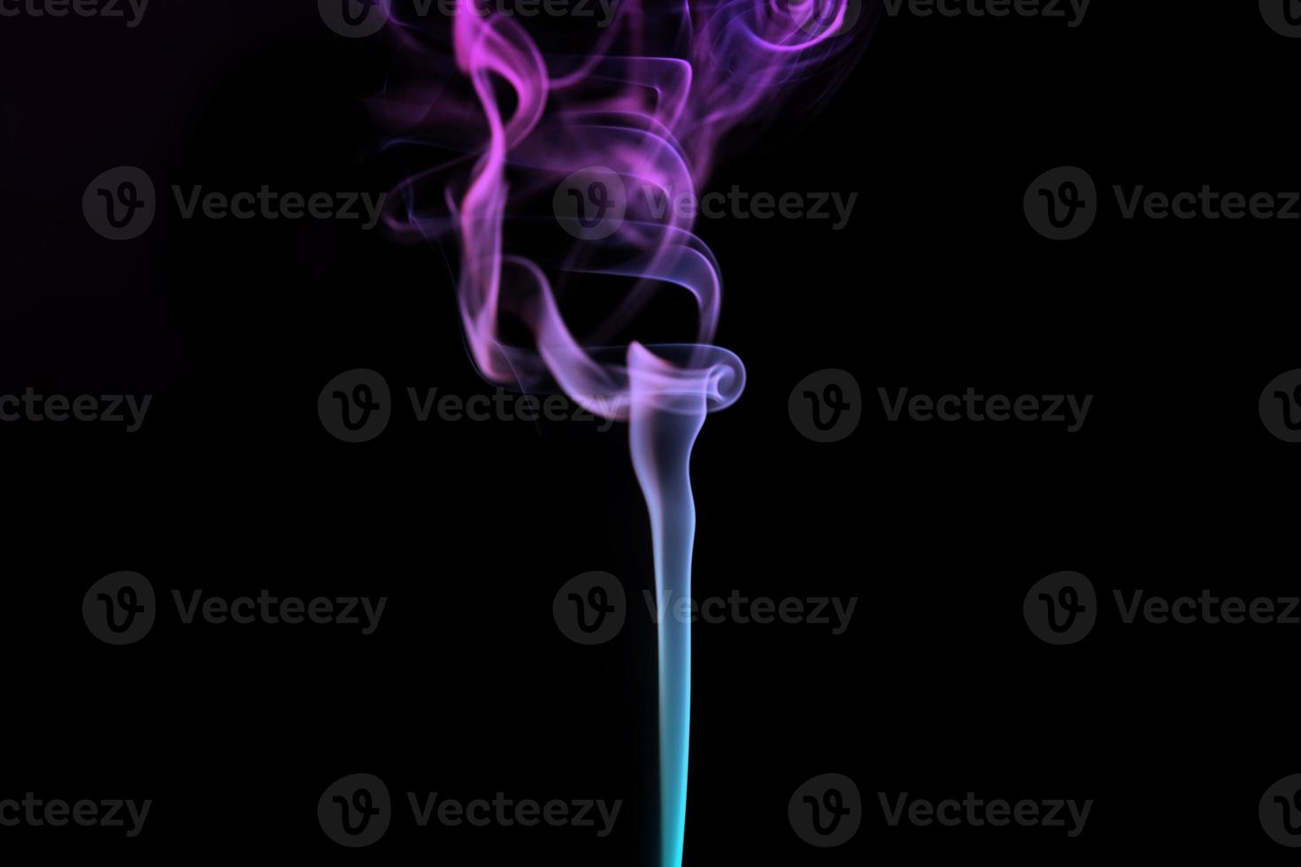Multicolored smoke for aromatherapy relaxation on black background, beautiful swirled puffs of smoke photo