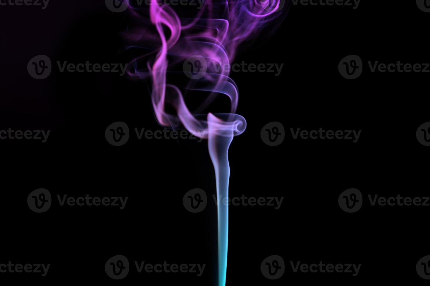 humo multicolor para la relajación de la aromaterapia en el fondo negro, hermosas bocanadas de humo en espiral foto