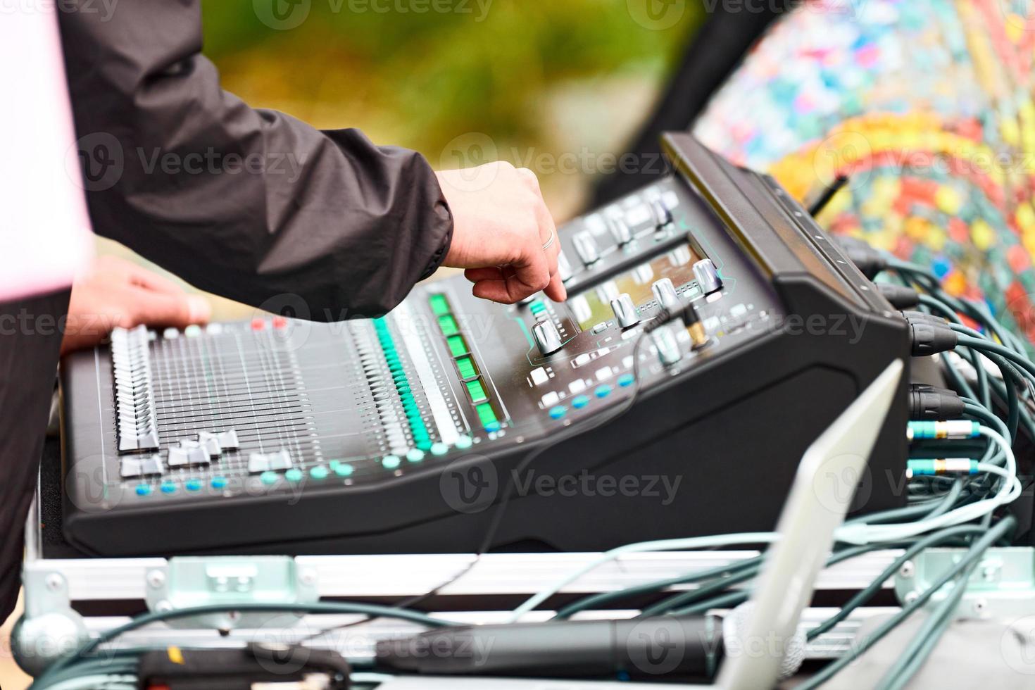 Manos de ingeniero de sonido trabajando en mezclador de sonido en concierto en vivo, mezclador de sonido de escenario, control deslizante de mezcla de audio foto