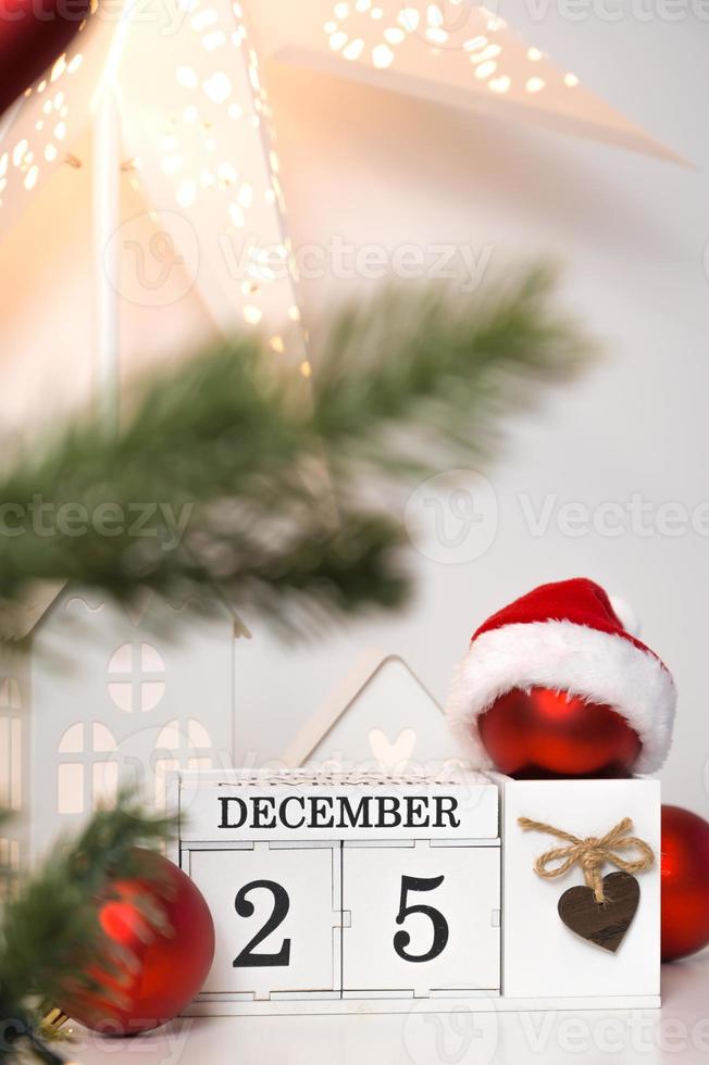 Vertical christmas banner in red,white and green colors with calendar,toy houses,sanat hat and shining star. Cozy greeting card photo