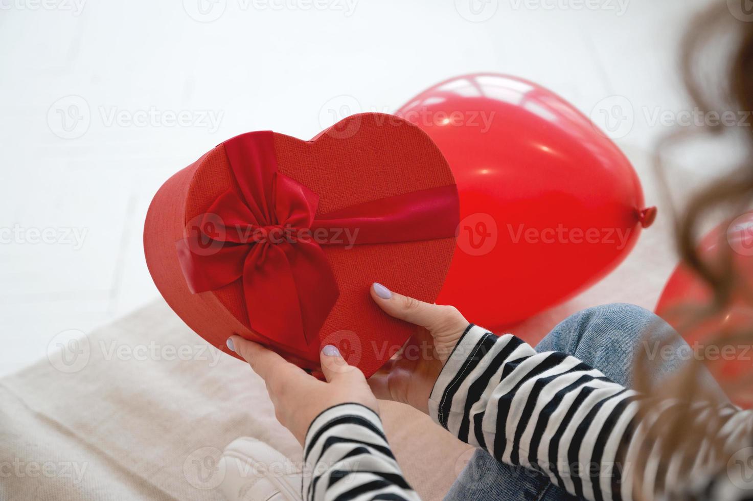 Close up of woman hold gift box red heart for Valentines Day.Delivery present. photo