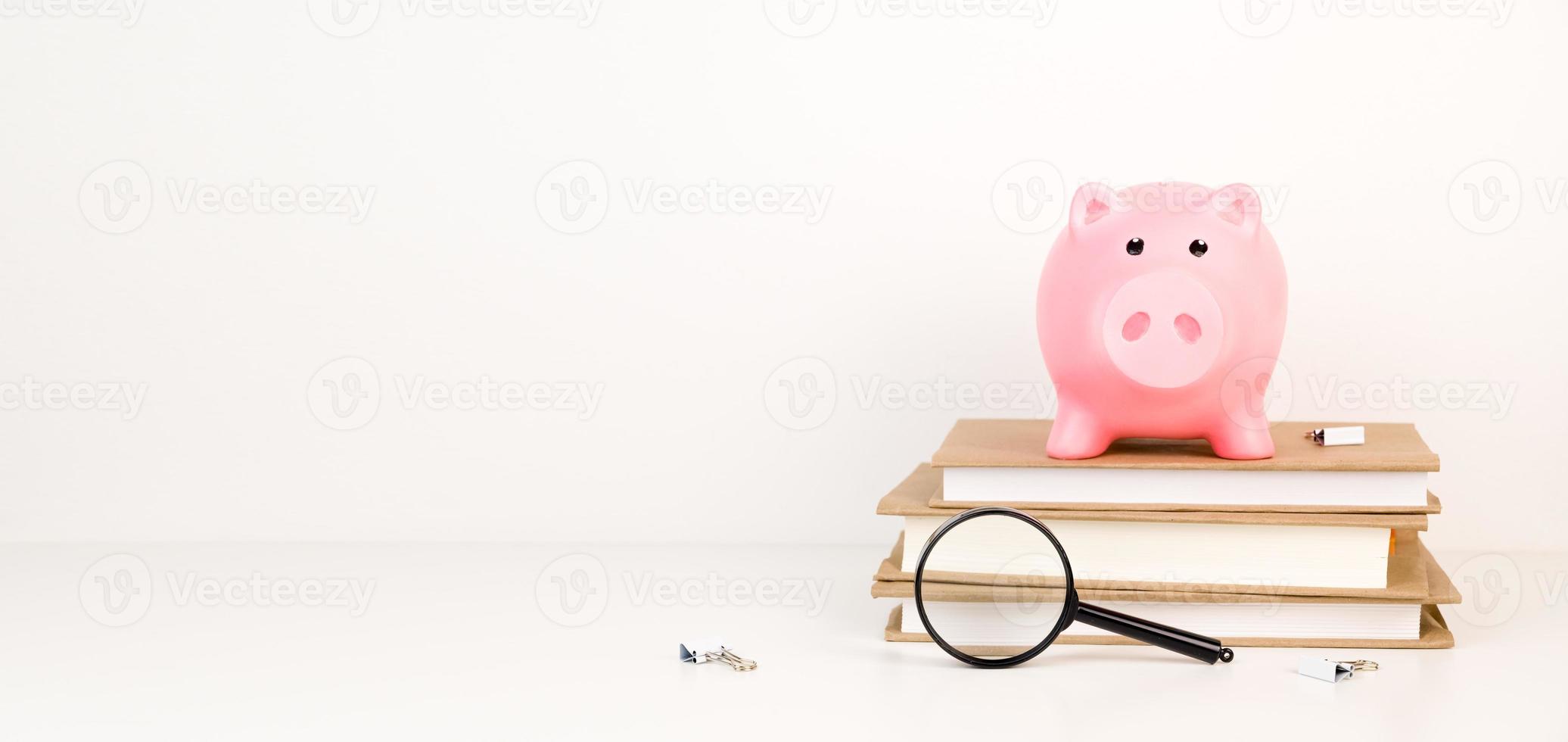 Pink Piggy bank on top of books with as concept image of the costs of education or research. Education or research fund.Scholarship concept.Banner with place for text photo