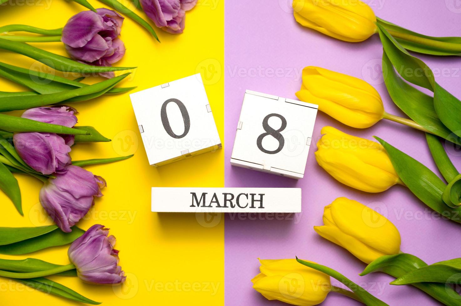 Women's day flat lay in yellow and purple colors. 8 march calendar near a bunch of flowers photo