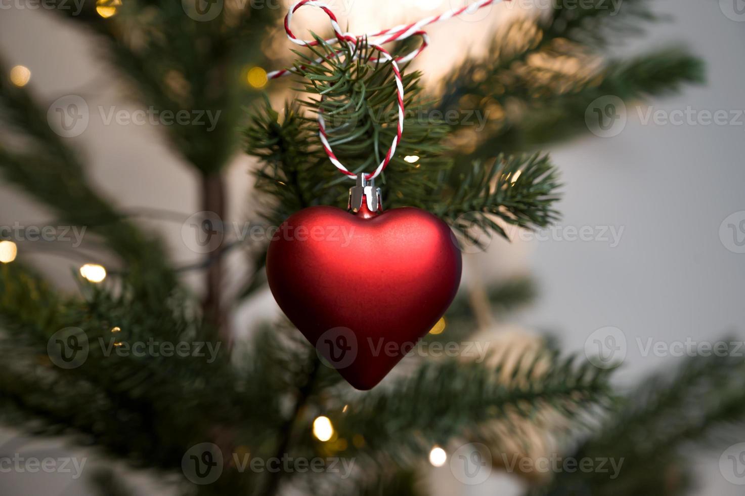 Christmas or new year banner with heart shaped ornament haning on branches with bokeh from lights. photo