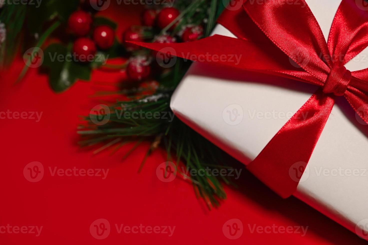 Christmas composition. Gift box, christmas decorations against red background,copyspace photo
