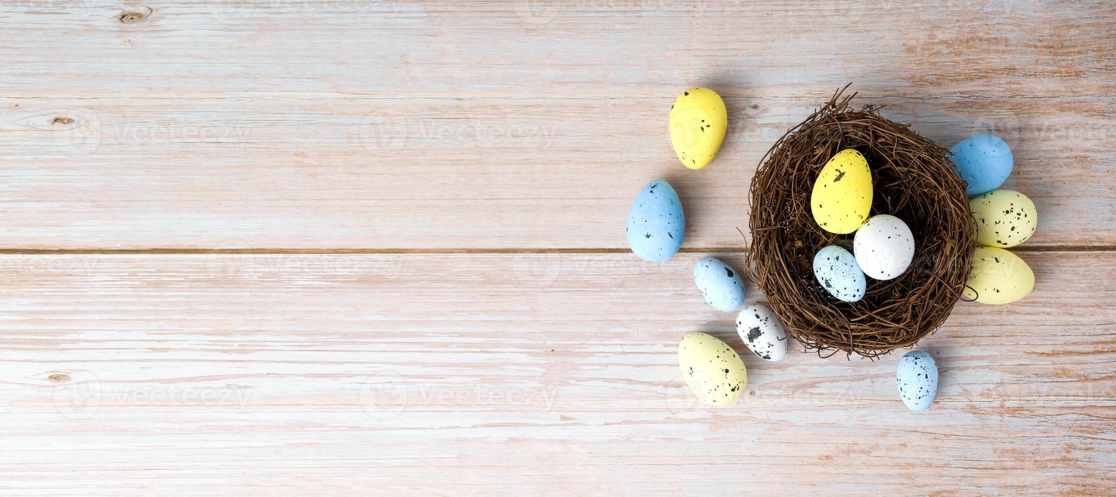 Top view on white,yellow and blue eggs in th nest Happy easter banner.Banner with place for text photo