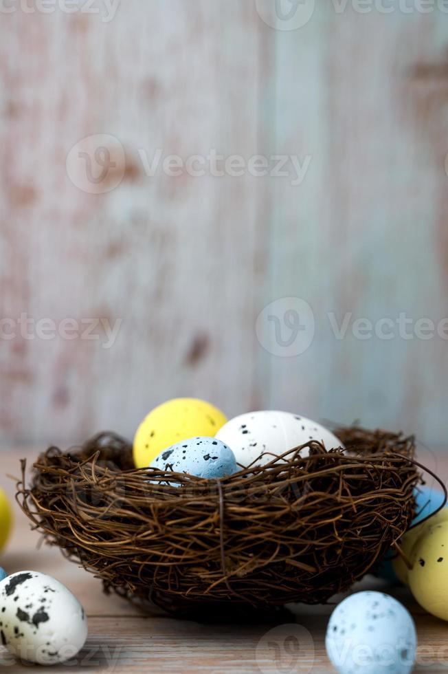 Nest filled with white,yellow and blue eggs. Happy easter banner with place for text.Vertical banner photo
