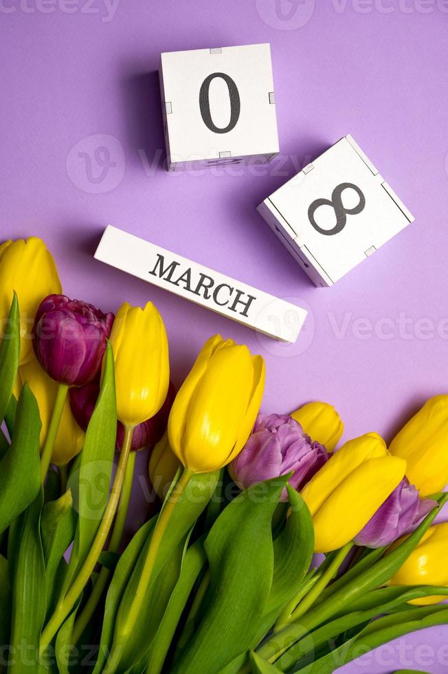 Vertical shot with Women's day flat lay. 8 march calendar near a bunch of flowers photo