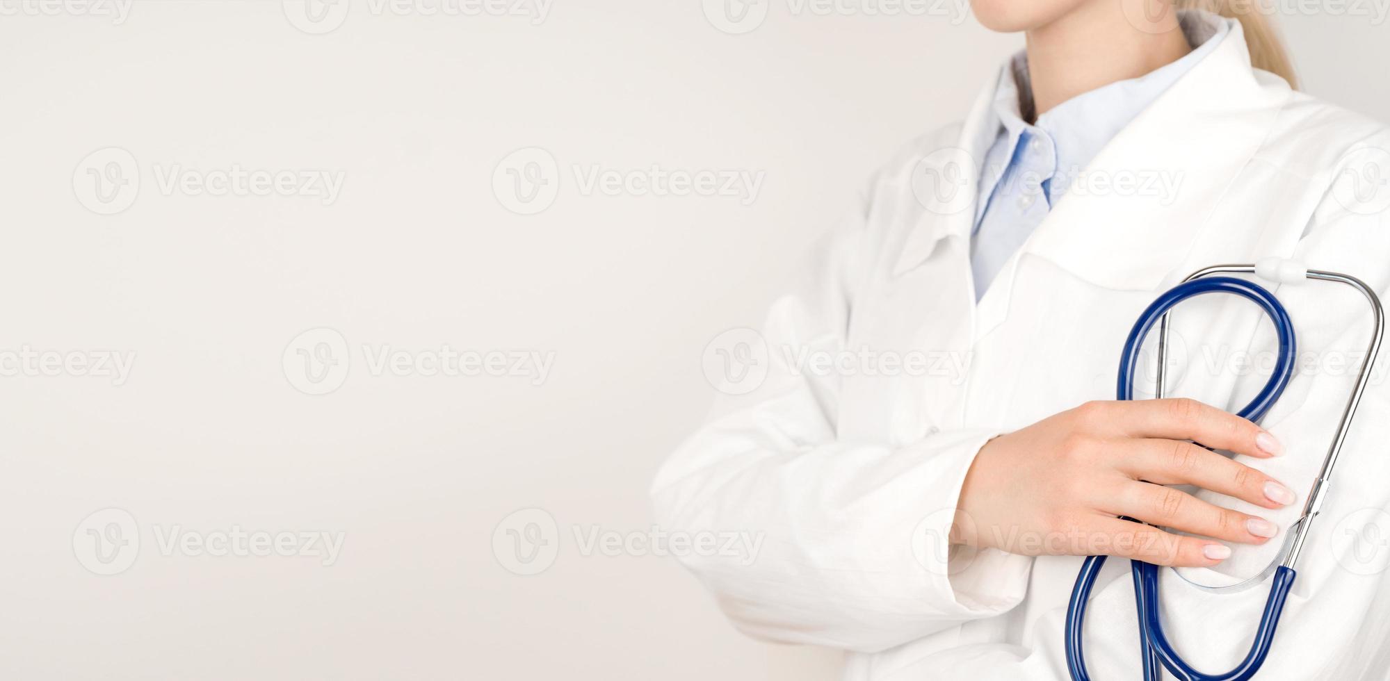 Healthcare concept panoramic banner.Unrecognizable doctor in white lab coat holding stethoscope in hands.Template and copy space banner photo