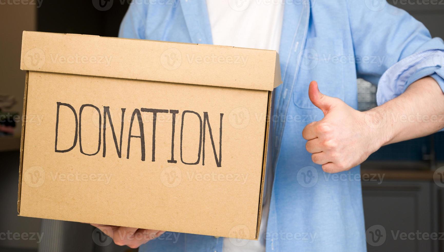 Closeup of a male volunteer holding donation box. Charity.Helping.Clothes photo