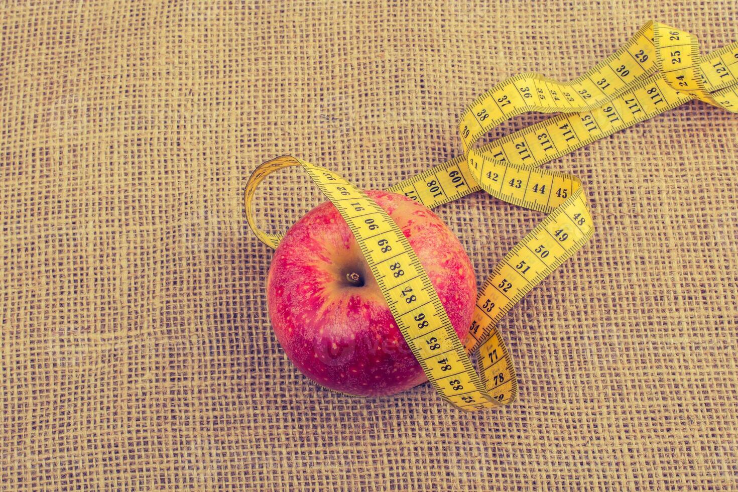 Red apple with a measurement  tape on it photo