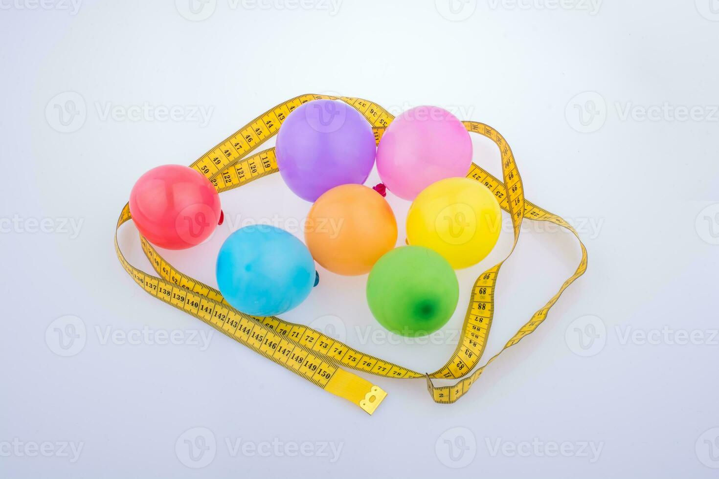 globos de colores rodeados de cinta métrica con fondo de fiesta de celebración foto