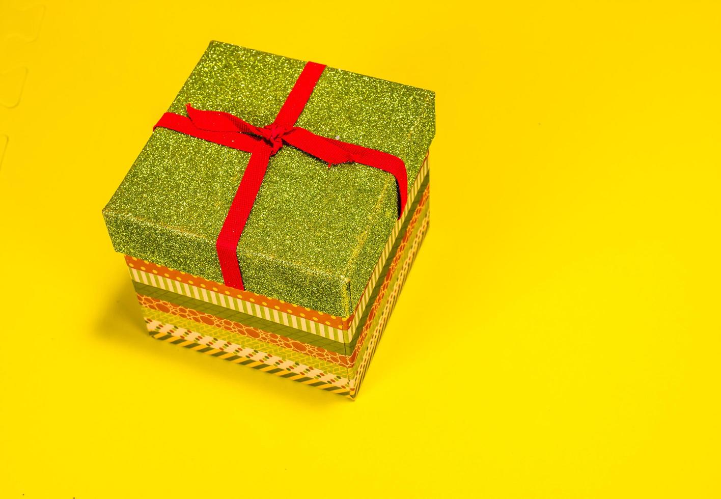 Colorful Christmas Gift Box On Yellow Background photo