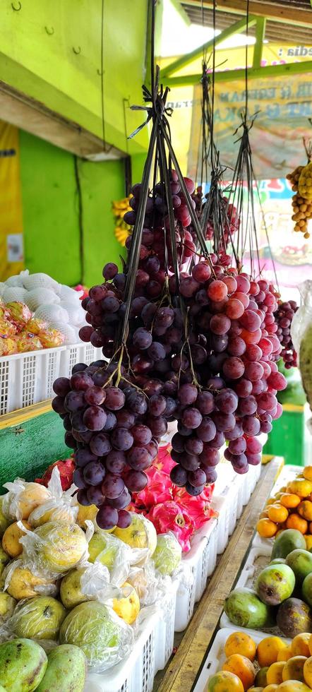 Several bunches of grapes hanging in the fruit shop, photo taken from the side angle